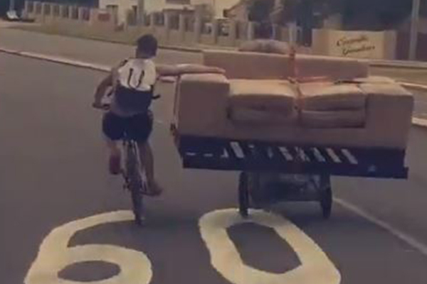 Article image for WATCH | Two men transport couch on their bikes